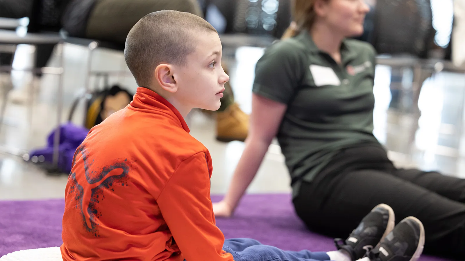 Boy seated on floor listening intently