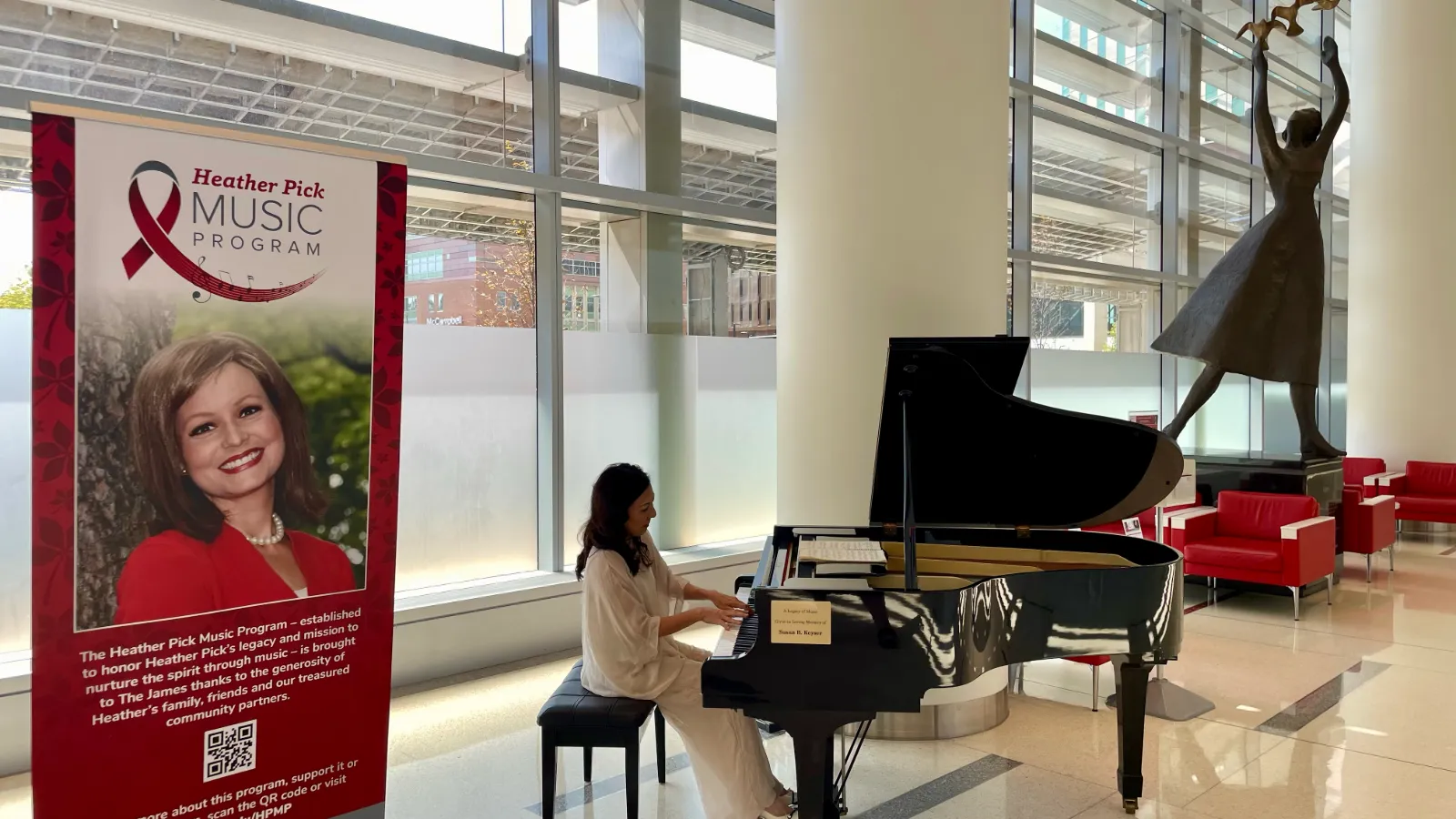 Pianist in white gown playing grand piano