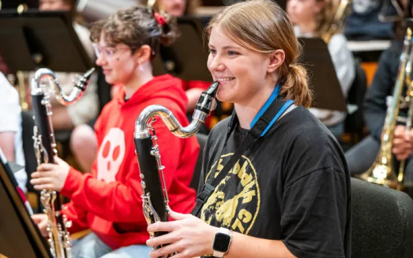 Two female students smiling in band rehearsal