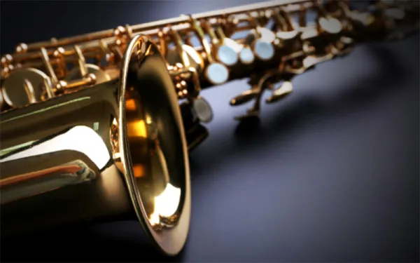 Saxophone lying on its side on a gray-blue background