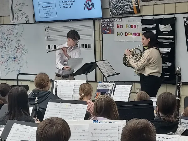 Flute and Horn player performing in a high school band class