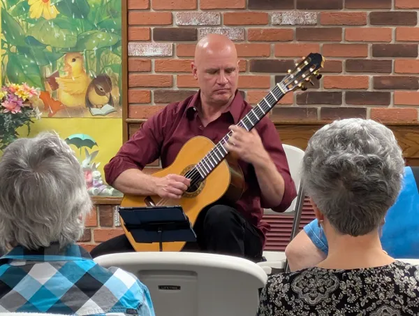 Karl Wohlwend playing guitar for audience