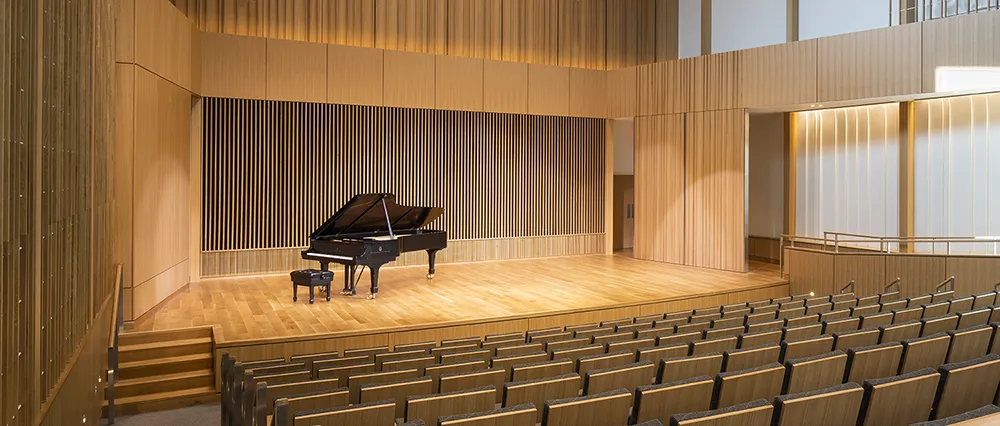 Black grand piano sitting on stage 