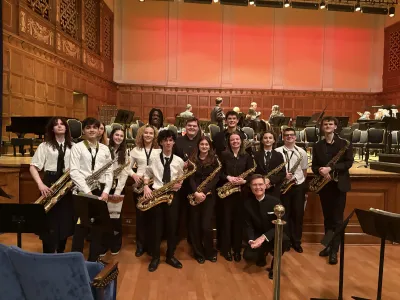 School of Music students, Liberty HS students, and Dr. Scott Jones posing with instruments